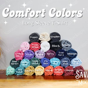 May include: A display of rolled up long-sleeved t-shirts in various colors, including blue, green, red, and purple. The t-shirts are arranged in a pyramid shape, with the text "Comfort Colors Long Sleeve T-Shirt" at the top.