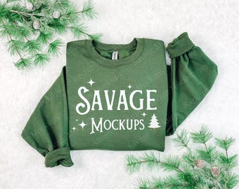 May include: A green sweatshirt with the text "Savage Mockups" in white lettering. The sweatshirt has a Christmas tree graphic and stars.