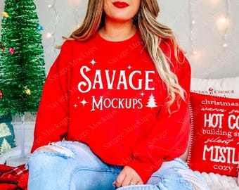 May include: A red sweatshirt with the text "SAVAGE MOCKUPS" in white. The model is wearing blue jeans.