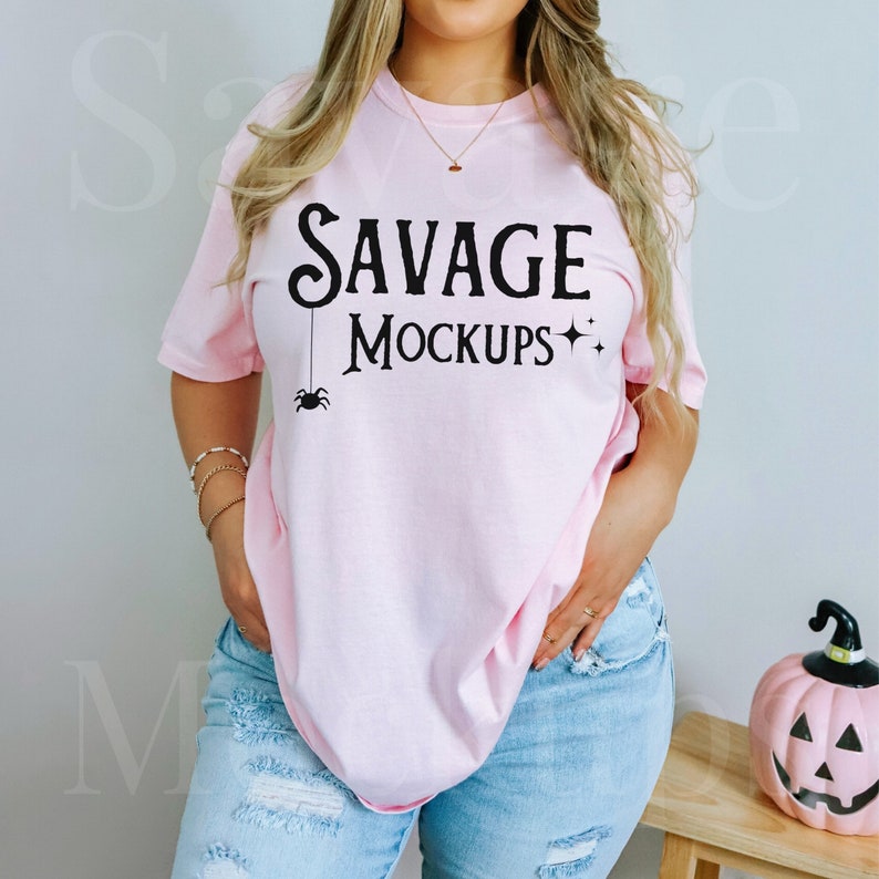 Puede incluir: Una camiseta rosa con el texto "SAVAGE MOCKUPS" y una ara&ntilde;a negra colgando de la palabra "SAVAGE".