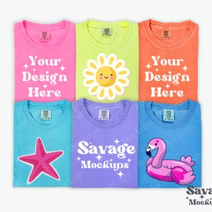 May include: Five different colored t-shirts with various designs. The designs include a smiling sun, a pink starfish, a pink flamingo float, and the text "Your Design Here" and "Savage Mockups".
