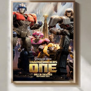 May include: A framed poster for the film "Transformers One", showcasing robot characters in red, grey, pink, and yellow. The poster includes the text "Witness the Origin" and "Only in Theatres September 2024".