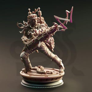 Puede incluir: Figura detallada de un personaje steampunk, sosteniendo un arma grande y adoptando una pose dinámica. La figura es marrón con intrincados detalles mecánicos, incluyendo gafas, una mochila y una base circular. Un efecto de energía rosa emana del arma.