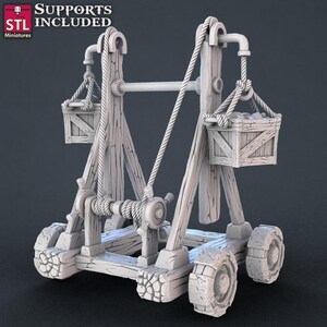 May include: A wooden catapult with a rope and pulley system. The catapult has two baskets, one on each side, and four wheels. The catapult is made of wood and has a weathered look.