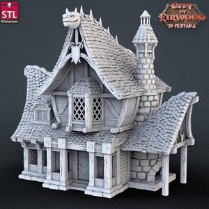 May include: A 3D printed model of a two-story building with a dragon head on the roof. The building has a chimney, a door, and several windows. The model is made of gray plastic and is designed for tabletop gaming.