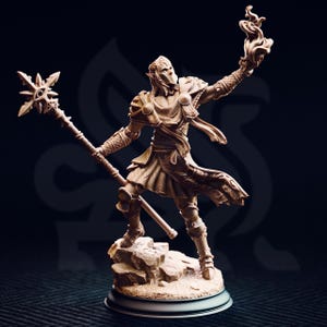 Può includere: Statuetta dettagliata di un personaggio fantasy, che tiene in una mano un bastone con una stella in cima e nell'altra un oggetto in fiamme. La figura è vestita con un'armatura e si trova su una base rocciosa, con uno sfondo scuro.