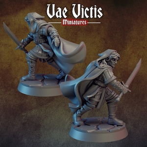 May include: Two gray plastic miniature figures of people wearing cloaks and holding swords. The figures are standing on round bases.