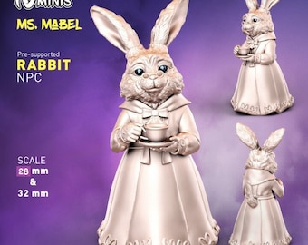 May include: A pre-supported 3D printed model of a rabbit wearing a dress and holding a teacup. The model is 28 mm and 32 mm in scale. The model is painted in a metallic gold color.