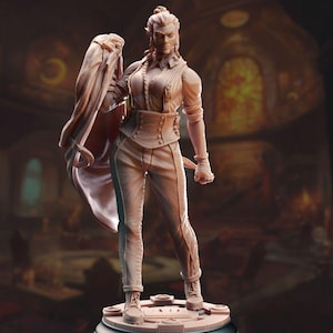 May include: A detailed figurine of a woman wearing a long-sleeved shirt, trousers, and a jacket. She has a serious expression and is holding a small object in her right hand. The figurine is painted in a light brown colour.