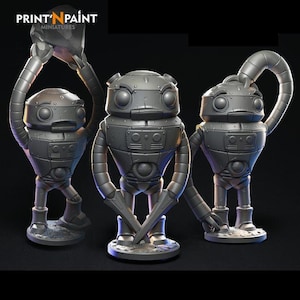 May include: Three gray robot miniatures with detailed mechanical features. One robot holds a rock above its head, another holds crossed blades, and the third has a curved arm. The text "PRINT'N PAINT MINIATURES" is at the top.