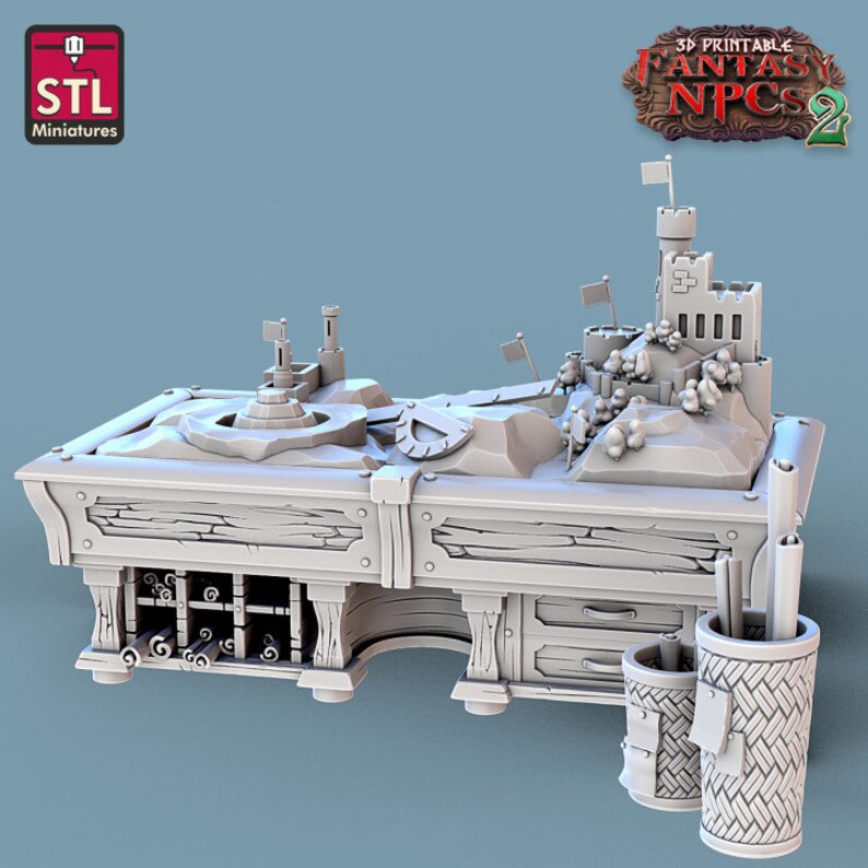 May include: A 3D printed model of a wooden table with a sandcastle scene on top. The table has a shelf underneath and a drawer on the side. There are two cylindrical containers with scrolls and pencils on the side of the table. The text on the table reads '3D Printable Fantasy NPCs 2'.