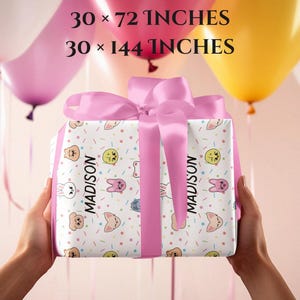 May include: Pink wrapping paper with a white background and a repeating pattern of cartoon animals and confetti. The paper is rolled up and tied with a pink ribbon. The text "MADISON" is printed on the paper. The text "WRAPPING PAPER SIZES:" is printed above the paper. The text "30 x 20 INCHES", "30 x 72 INCHES", and "30 x 144 INCHES" is printed below the paper. The text "FREE SHIPPING!!!" is printed below the paper.