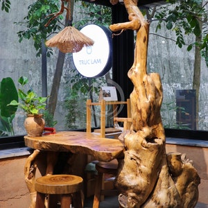 May include: A wooden table and stool set with a unique, natural design. The table and stool are made from a single piece of wood, with the natural bark and knots still intact. The table has a rustic, organic look and would be a great addition to any home.