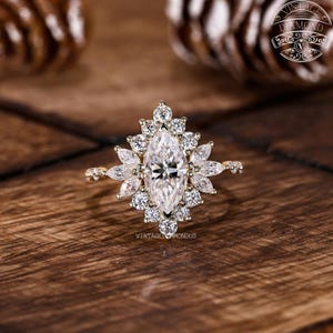 Handmade marquise-cut lab-grown diamond ring with a floral halo arrangement. The 1.00 CT center diamond is surrounded by alternating round and marquise accent diamonds for enhanced brilliance. Crafted in yellow gold, this ring offers a timeless design ideal for engagements and special celebrations.