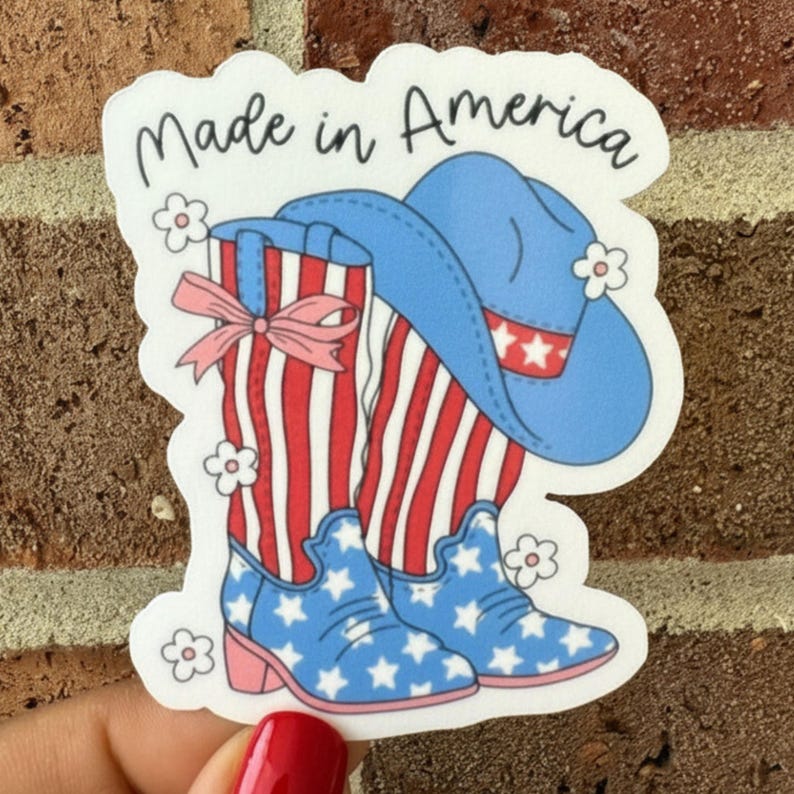 May include: A sticker featuring a patriotic design with a cowboy hat and boots. The boots have a red and white striped pattern with a pink bow and blue star-patterned accents. The hat is blue with white stars and red stars. The text "Made in America" is at the top.
