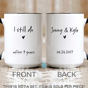 May include: A white ceramic mug with a black handle and rim. The front features the black text I still do after 9 years with a small heart. The back displays the black text Jenny & Kyle with a heart and the date 06.26.2017.