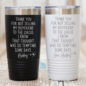 Puede incluir: Dos vasos de acero inoxidable con fondo blanco y texto negro. El texto en los vasos dice "Gracias por no vender a mi novio al circo Sé que esa idea fue muy tentadora algunos días Ashley". Un vaso tiene el texto "Love, Ashley" en la parte inferior.