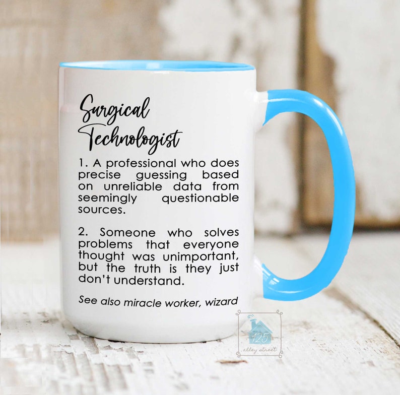 Puede incluir: Taza de cer&aacute;mica blanca con borde y asa de color azul claro. La taza tiene texto negro que dice "Surgical Technologist" y una definici&oacute;n del t&eacute;rmino.