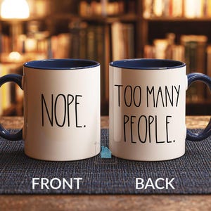 May include: A set of three ceramic mugs with a speckled, matte finish. The mugs are in shades of cream, light gray, and dark gray. Each mug has a simple, minimalist design and a rounded handle.