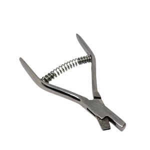 May include: A silver metal tool with a spring and two handles. The tool is used for cutting leather.