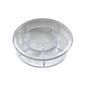 May include: Clear plastic container with multiple compartments. The container is round and has a lid.