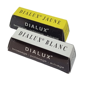May include: Two bars of DIALUX polishing compound. One is in a yellow box with black text reading "DIALUX® JAUNE". The other is in a brown box with white text reading "DIALUX® BLANC". Both boxes have the words "brossage - polissage - avivage".