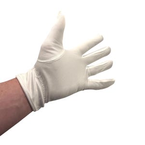 May include: A single white glove made from a smooth fabric. The glove is on a hand, with the fingers extended. The wrist area has an elasticated band. The background is plain white.