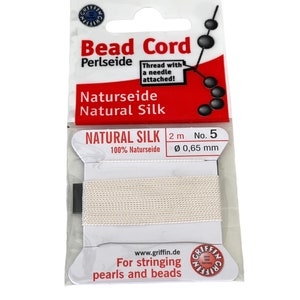 May include: A spool of white natural silk bead cord for stringing pearls and beads. The label reads "Bead Cord Naturseide Natural Silk" and "2 m No. 5 Ø 0,65 mm".