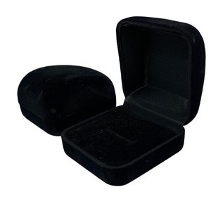 May include: Two black velvet ring boxes. One box is open and the other is closed.