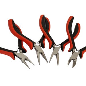 May include: A set of four metal pliers with red and black ergonomic rubberised handles. The collection includes round-nose, needle-nose, and wire-cutting pliers, all featuring polished silver-toned steel heads and curved, non-slip grip handles.