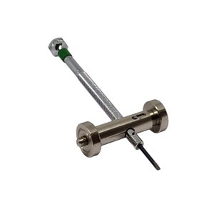 May include: A silver watch case opening tool with a green handle and a small screwdriver attached. The tool has two wheels on either side of the handle.