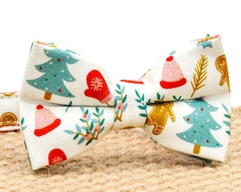 Könnte beinhalten: Ein weißer Weihnachts-Fliege mit einem roten, grünen und goldenen Muster. Die Fliege ist an einem roten und weißen Halsband mit einer goldenen Glocke befestigt.