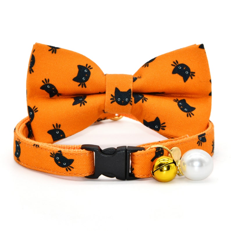 May include: Orange cat-print breakaway cat collar with a matching bow tie and a gold bell and pearl charm.