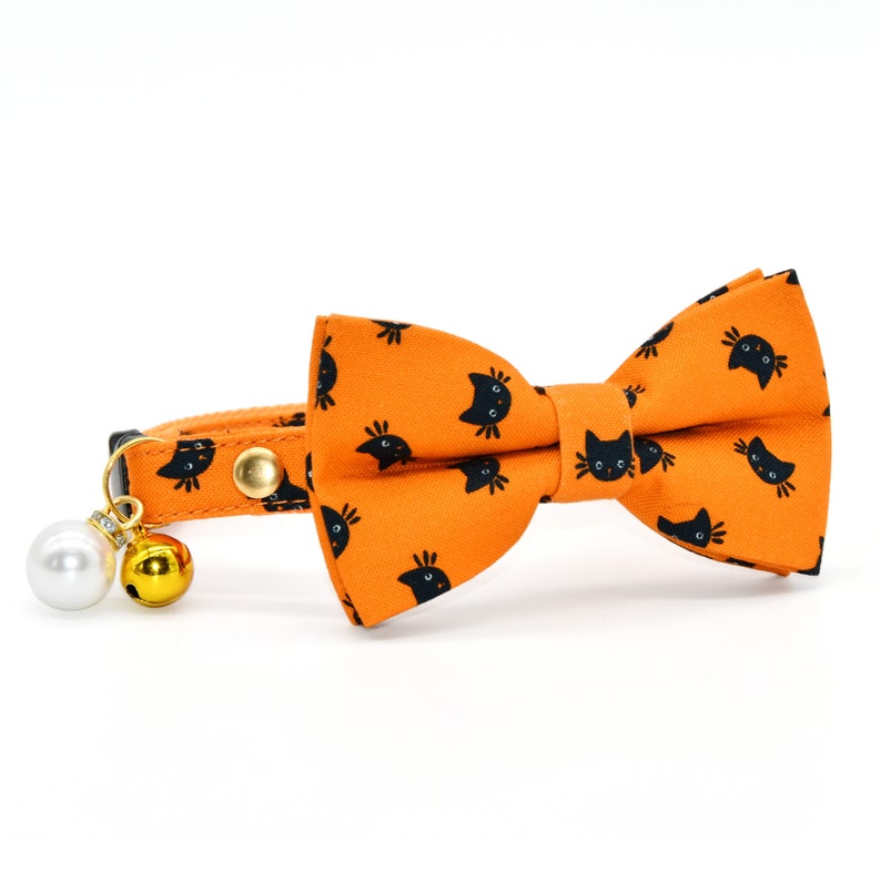 May include: Orange cat-print bow tie collar with a white pearl and gold bell charm.