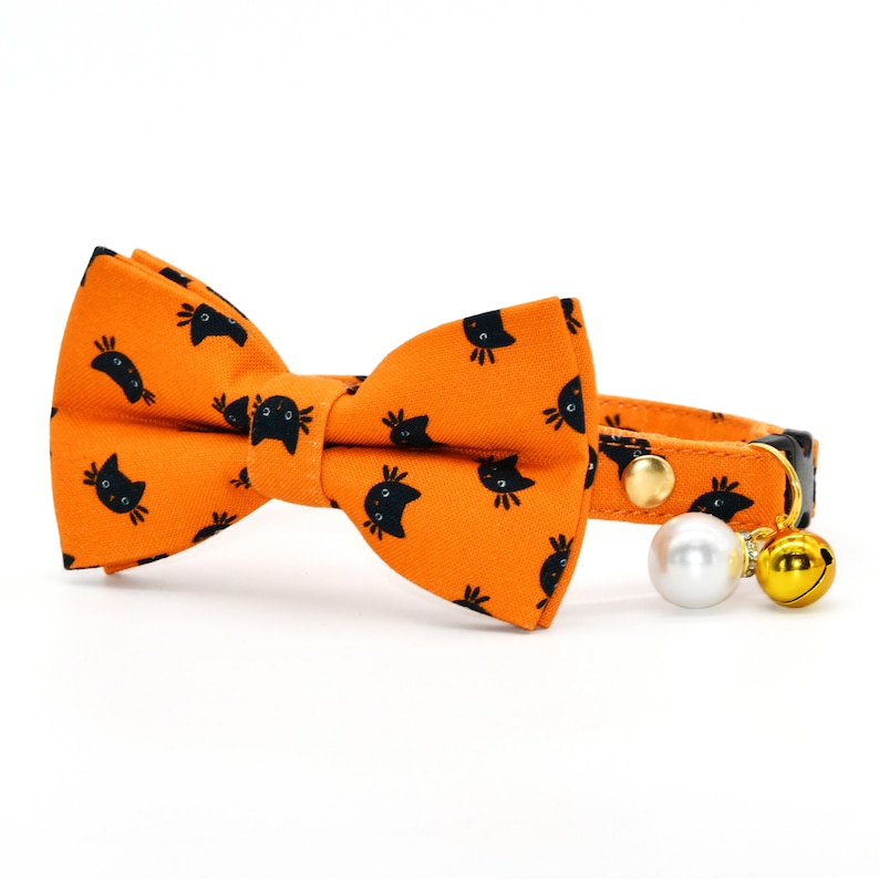 May include: Orange cat-print bow tie with a black collar and a pearl and bell charm.