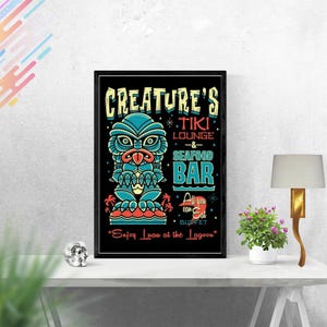 May include: A black and white poster featuring a tiki-style illustration of a creature from the black lagoon. The poster advertises "Creature's Tiki Lounge & Seafood Bar" with the text "All you can Eat Buffet" and "Enjoy Luau at the Lagoon".