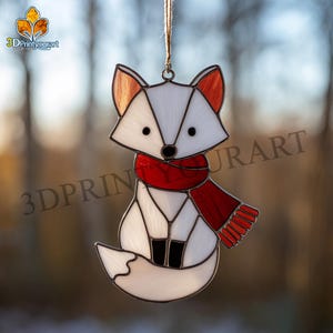 Könnte beinhalten: Ein Glasfenster-Fuchs-Ornament mit rotem Schal und braunen Ohren. Der Fuchs ist weiß mit schwarzen Augen und einer schwarzen Nase. Das Ornament hängt an einer braunen Schnur. Der Text "3DPrintyourart" ist sichtbar.
