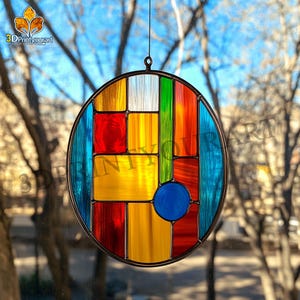 May include: A round stained glass window hanging with a geometric design featuring red, yellow, blue, green, and white glass pieces.
