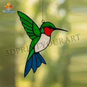 May include: A stained glass hummingbird with green wings, a red throat, white chest, and blue tail feathers. The bird is suspended by a thin wire, with the text "3DPrintyourart" visible in the image.