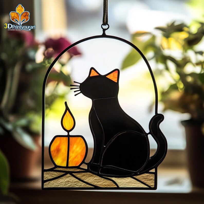 May include: A stained glass window hanging features a black cat sitting next to a lit candle. The cat is looking to the left and the candle is orange and yellow.