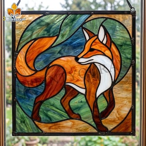 Pode incluir: Painel de vitral com uma raposa em tons de laranja, castanho e branco, sobre um fundo azul, verde e dourado. A raposa é estilizada, com uma borda preta. O painel é projetado para exibição em janelas, adicionando um toque decorativo.