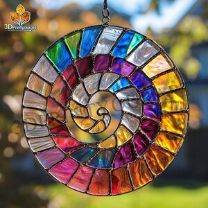 May include: A colorful stained glass suncatcher with a spiral design. The suncatcher is made of many small pieces of glass in various shades of red, orange, yellow, green, blue, purple, and white. The suncatcher is hanging from a chain.