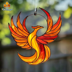 Peut inclure: Un phénix en verre coloré avec des ailes orange, jaunes et rouges. Le phénix est suspendu à un anneau métallique.