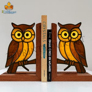 May include: Decorative owl bookends with stained glass effect. The bookends are brown, yellow, and orange, with the owl perched on a branch. Two books are held between the bookends, one with the title "Crystals" and the other "Edgar Cayce on Atlantis."