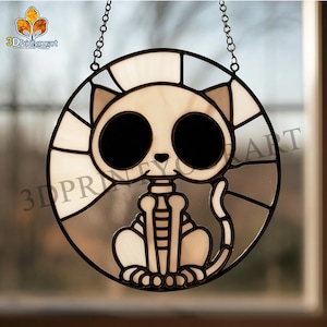 May include: A round stained glass cat skeleton suncatcher. The cat has large black eyes and a skeletal body. The design is in shades of white, gray, and black, with a chain for hanging. The text "3DPrintyourart" is visible.