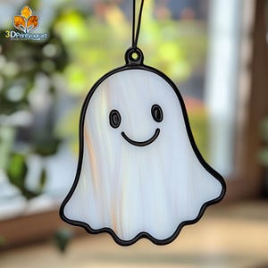 May include: A white stained glass ghost ornament with a black outline and a smiling face. The ghost is hanging from a black string.