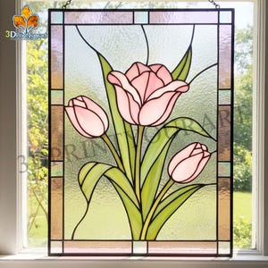 Puede incluir: Vidriera con tulipanes rosas con hojas y tallos verdes. El diseño floral se encuentra sobre un fondo texturizado, enmarcado por un borde negro. La ventana está colgada frente a una ventana.