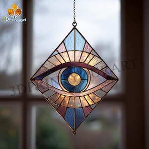 Puede incluir: Atrapasoles de vidriera en forma de ojo con diseño geométrico. El ojo presenta un iris azul y un párpado morado y azul. El atrapasoles está suspendido por una cadena y está hecho de varios colores de vidrio.