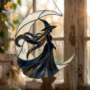 May include: A stained glass suncatcher featuring a crescent moon in iridescent white glass with a dark blue glass silhouette of a witch wearing a pointed hat and a flowing cloak, suspended by a thin black wire for hanging in a window.