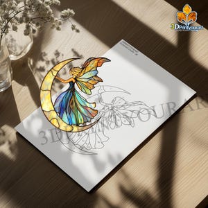 Op de afbeelding: Een glas-in-loodpatroon van een fee die op een halve maan zit. Het patroon is afgedrukt op een wit vel papier met de tekst "3DPrintYourArt Elegant Fairy - 48".